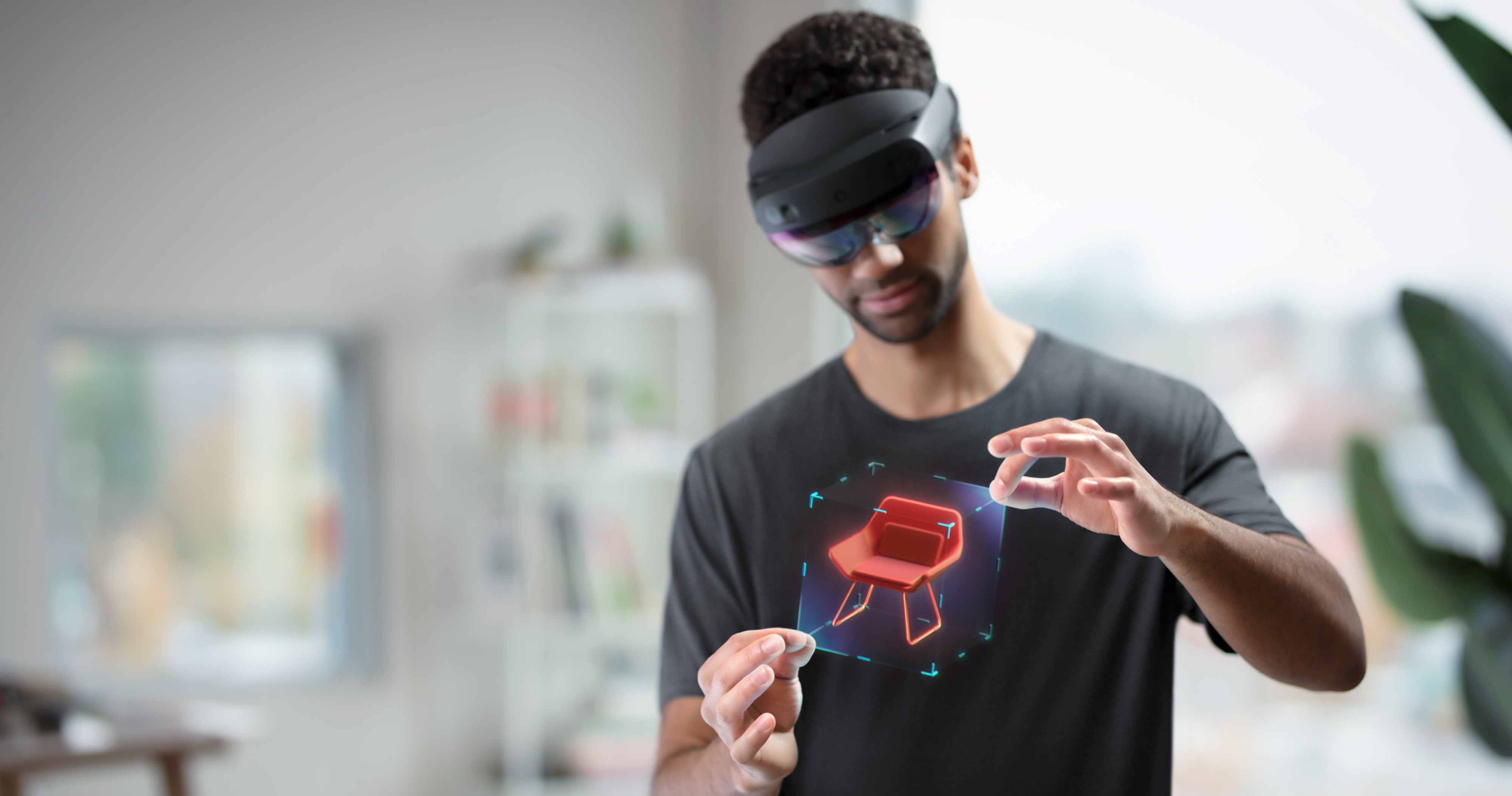 Abbildung eines Benutzers, der eine HoloLens trägt und ein Hologramm mit Handbewegungen manipuliert.
