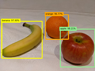 A banana, and orange, and an apple, each indicated by a bounding box and a probability scoreF