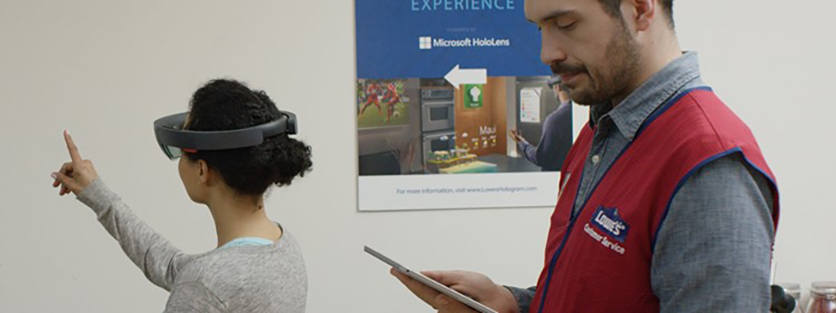 Un asociado de Lowe usa una tableta para guiar a los clientes a través de HoloLens experiencia.