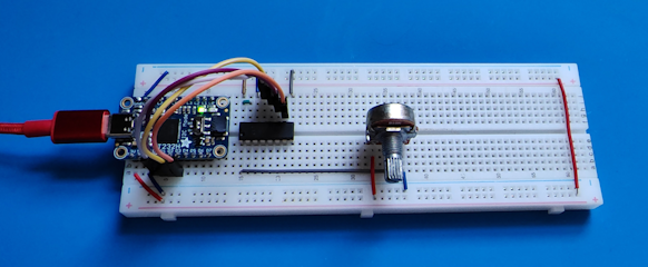 A picture of a breadboard with an FT232H adapter, an MCP3008 chip, and connecting wires.