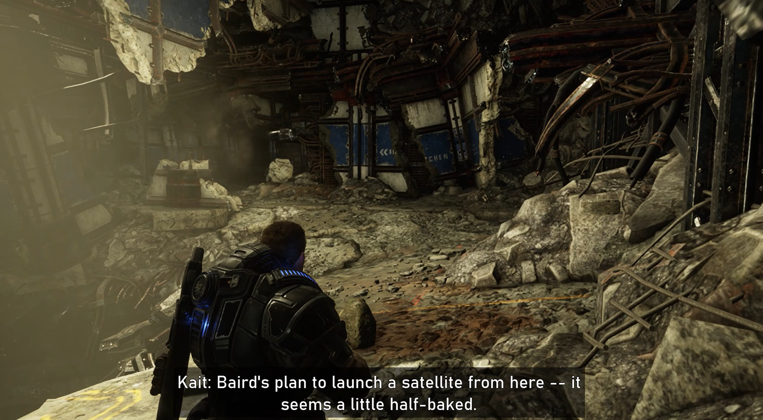 Gears 5 でのアクティブなゲームプレイ中に、半透明の背景に大きなテキストが表示された字幕。「Kait: Baird がここから衛星を打ち上げる計画です。まだ完成していないようです。」