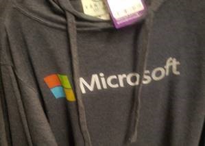 Szara bluza z etykietą firmy Microsoft i logo na nim