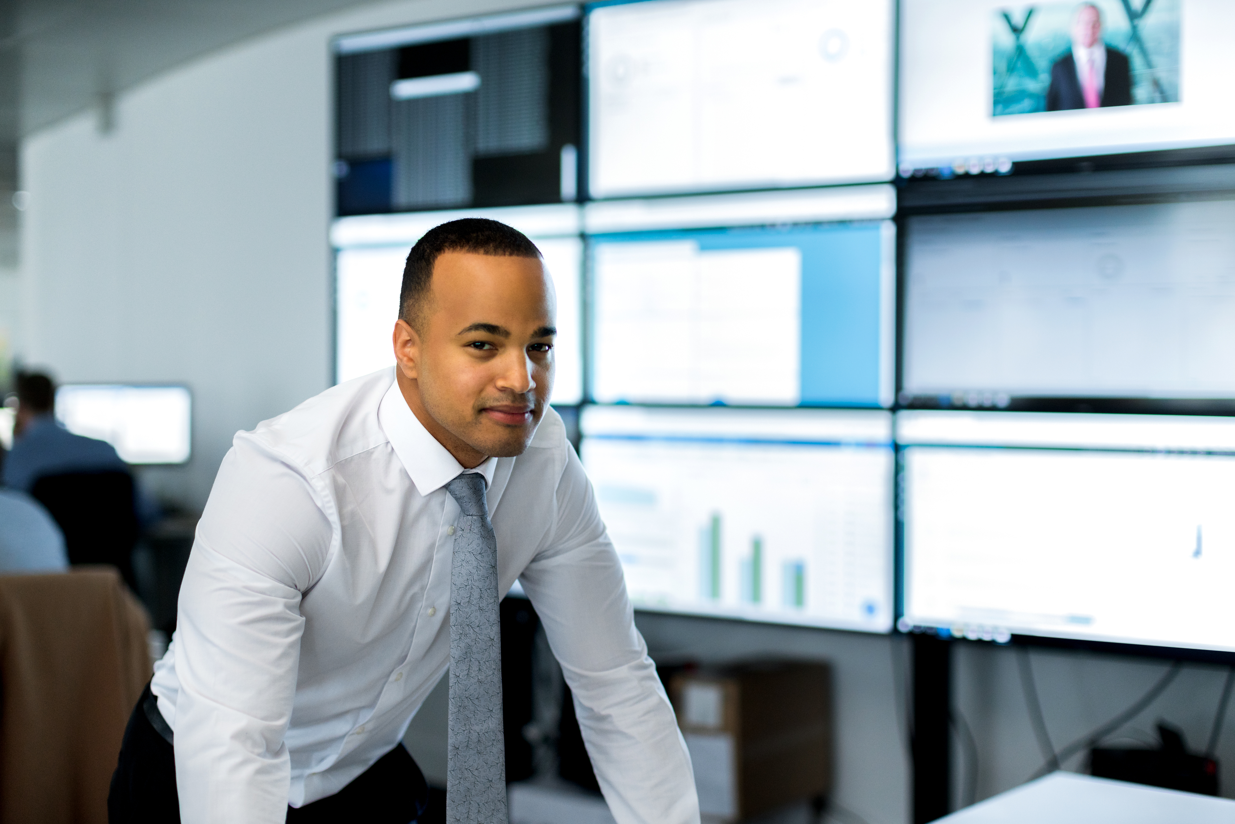 Um profissional da informação é retratado em frente de vários monitores.
