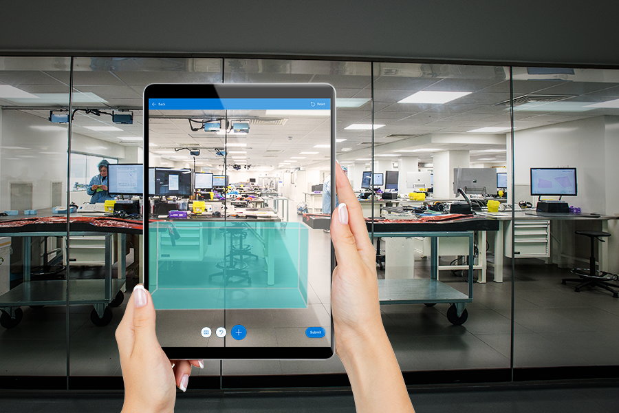 Uma foto de um ecrã de tablet que mostra um cubo digital sobreposto na vista do utilizador de um escritório.
